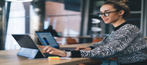 Focused woman working on tablet in modern workspace